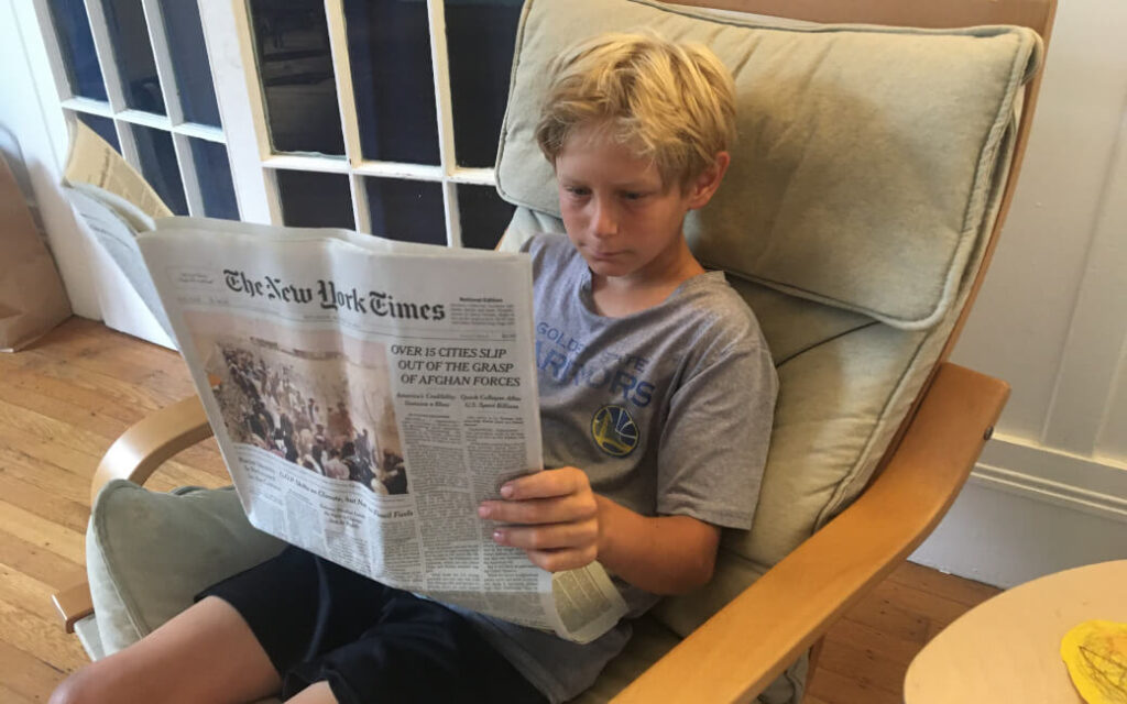 Young man sitting and reading the New York Times